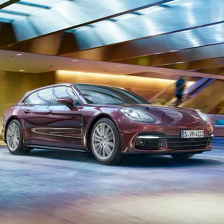 Mauve Porsche Panamera driving through street
